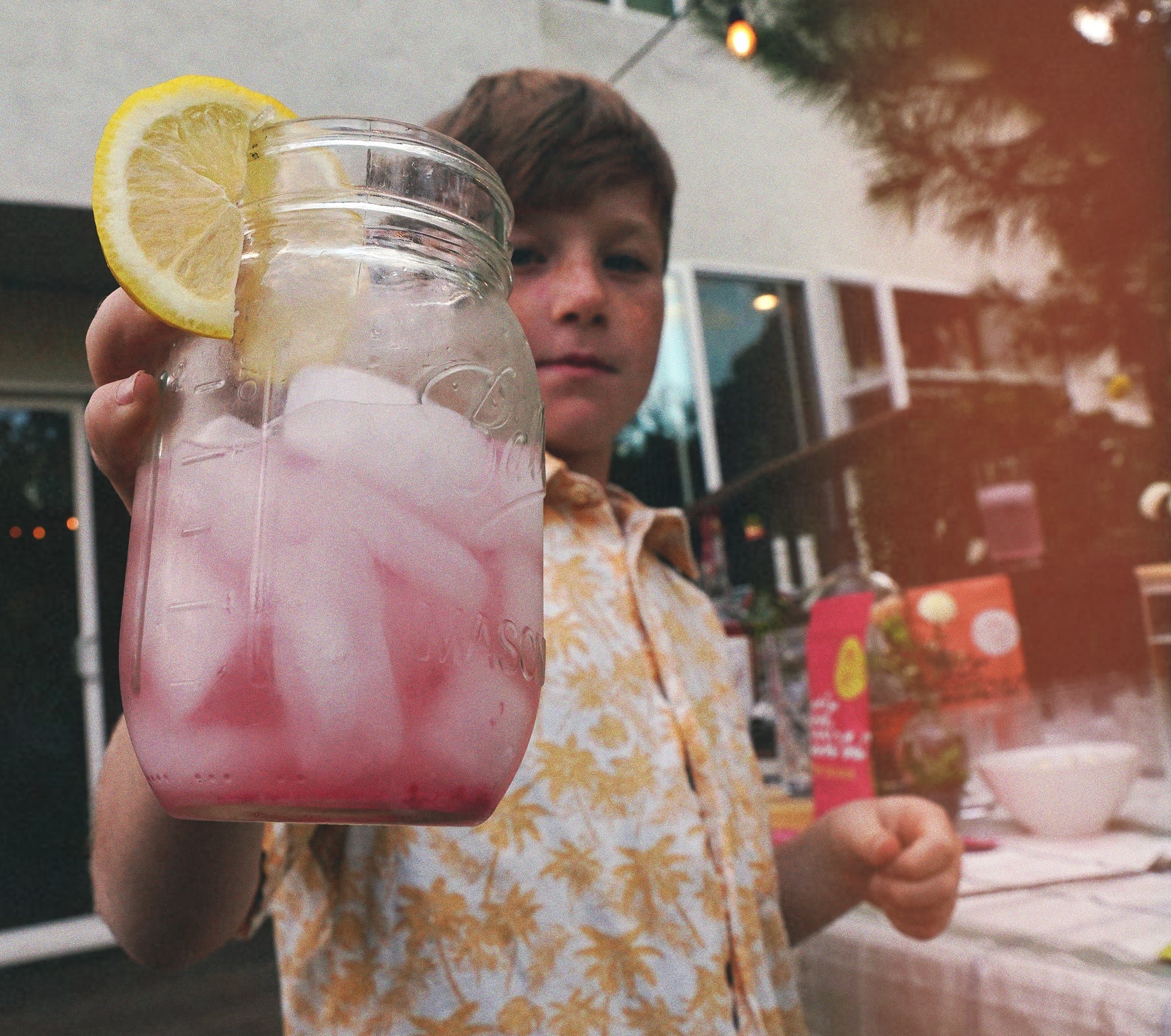Kid holding a non alcoholic mocktail raspberry lemonade. Easy and fun to make. 